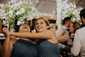 Bridesmaids in matching blue dresses sharing a joyful moment at a wedding reception.