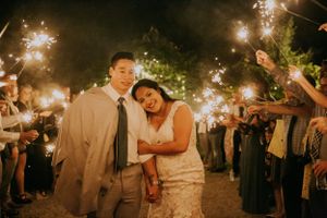 Newlyweds share an intimate moment surrounded by sparklers at their nighttime celebration.
