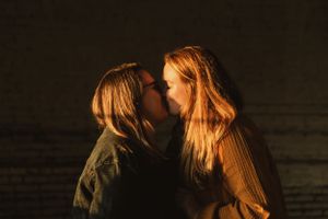 A silhouetted couple shares an intimate moment in dramatic lighting.