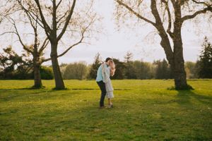 A loving embrace captured in golden sunlight with bare trees framing the scene.