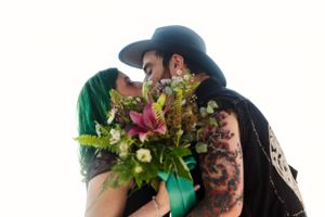 An intimate moment shared between a couple with a beautiful floral bouquet.