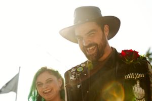 A joyful moment captured in bright sunlight at an outdoor celebration.