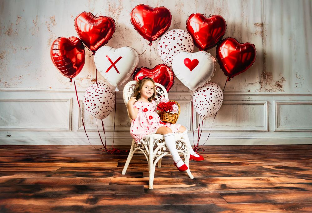 Valentine's themed decor featuring heart shaped balloons and white polka dot pattern against vintage wall background.