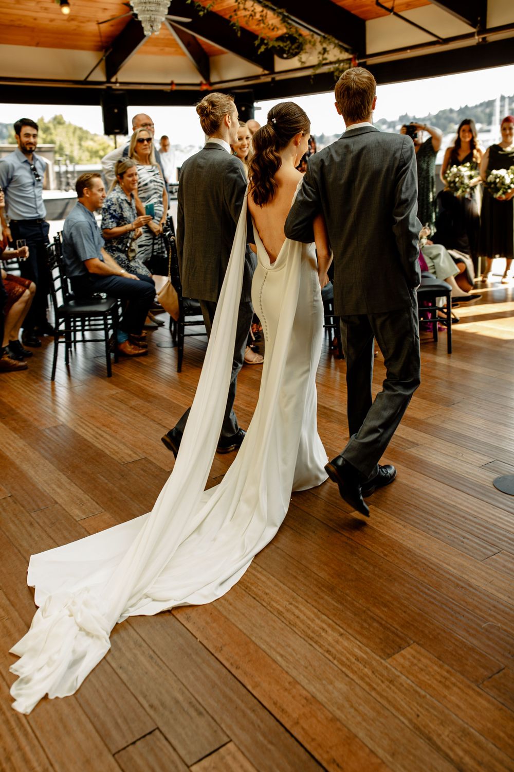 Elegant wedding reception scene with flowing white dress train on hardwood floor.