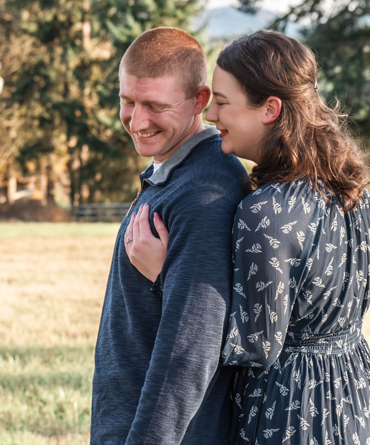A couple embraces and shares tender moments in a series of outdoor photos with golden sunlit fields in the background.