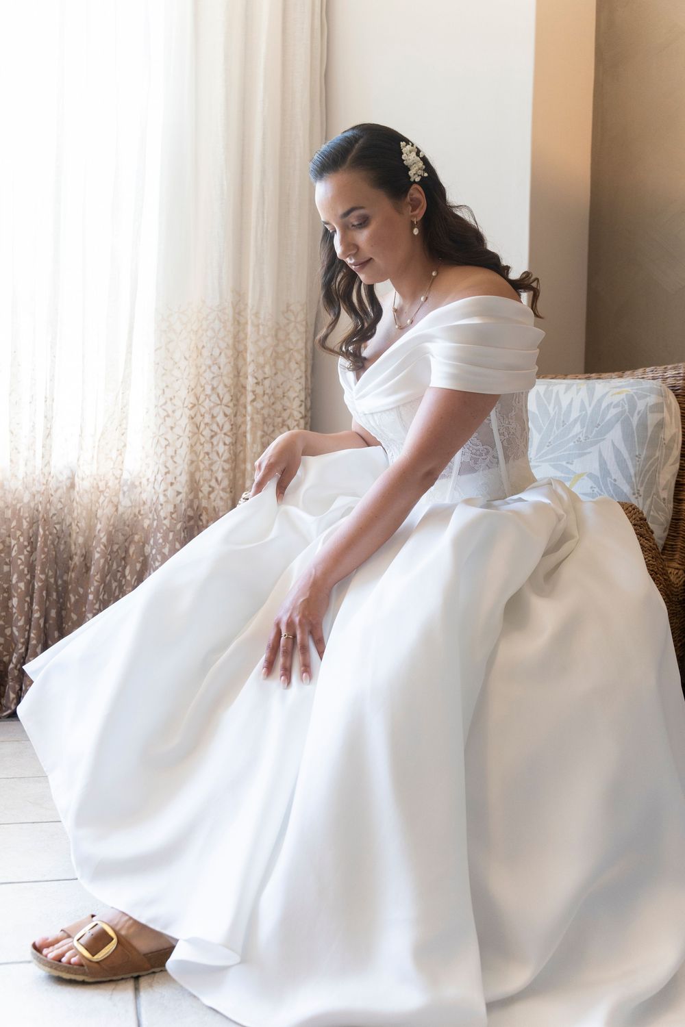 An elegant white wedding dress with voluminous skirt shown in a series of indoor detail shots.