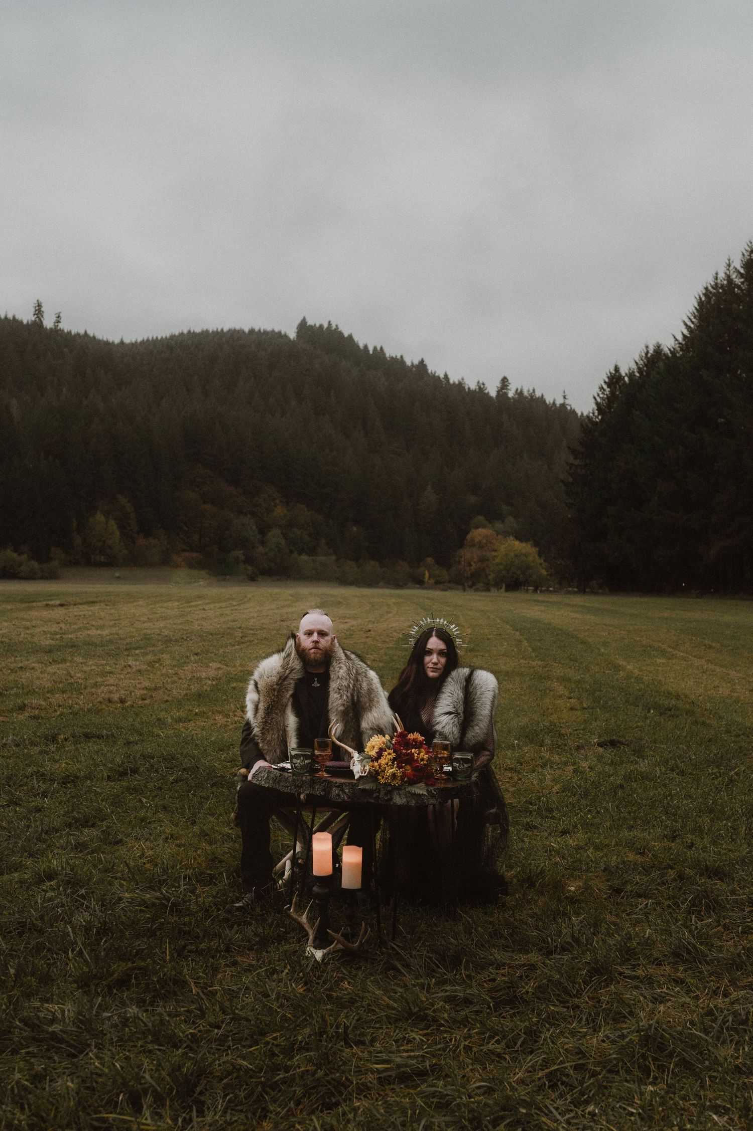 Cozy outdoor seating arrangement with lanterns in a misty mountain meadow.