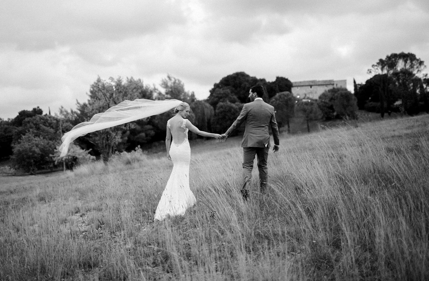 Bride and groom walking through Provence countryside during destination wedding