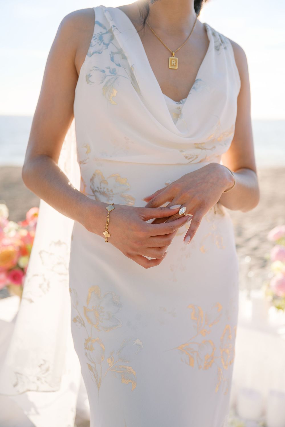 Close-up details of a white lace wedding dress showing delicate embroidery patterns in sunlit outdoor setting.