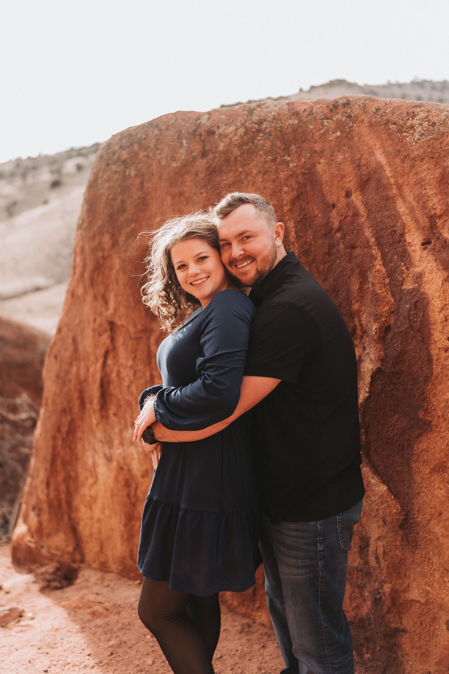 Makayla and Michael laughing during Red Rocks Amphitheatre engagement photos.