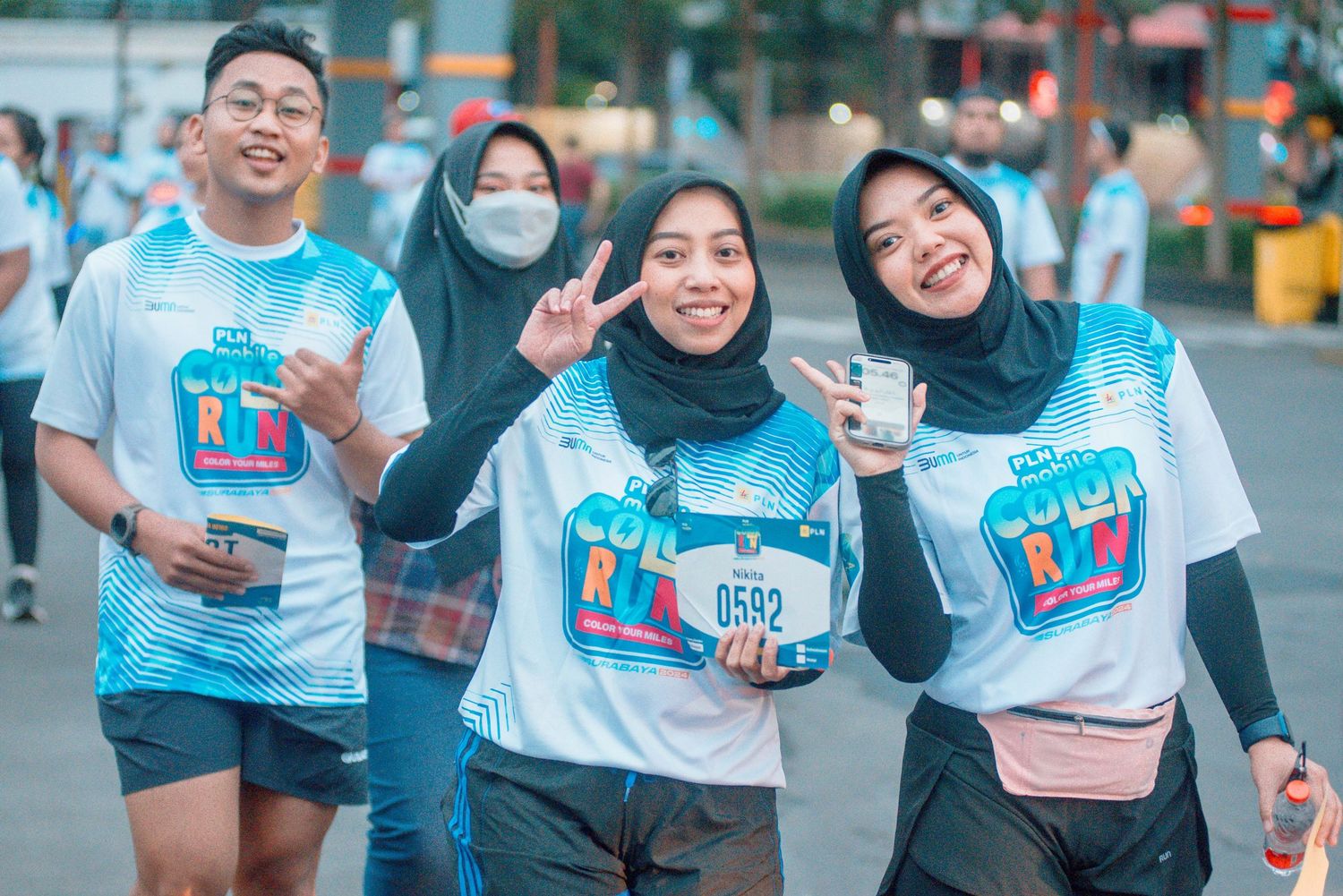 Group of runners in matching light blue shirts participating in a fun run event.