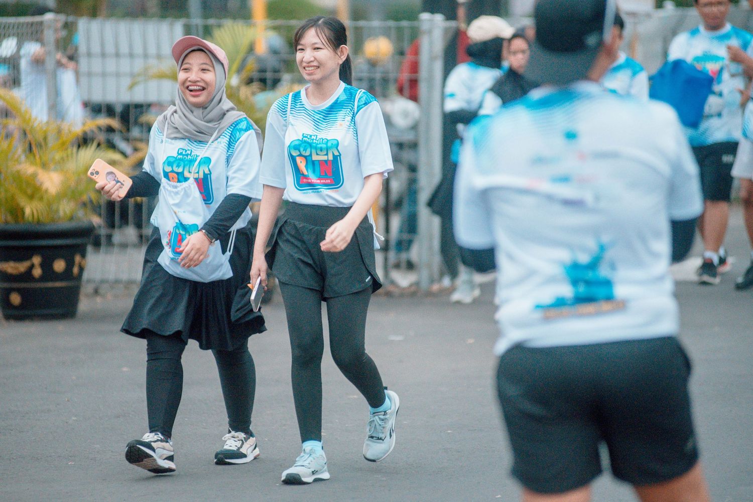 Athletes in sportswear running together during an outdoor community fitness event.