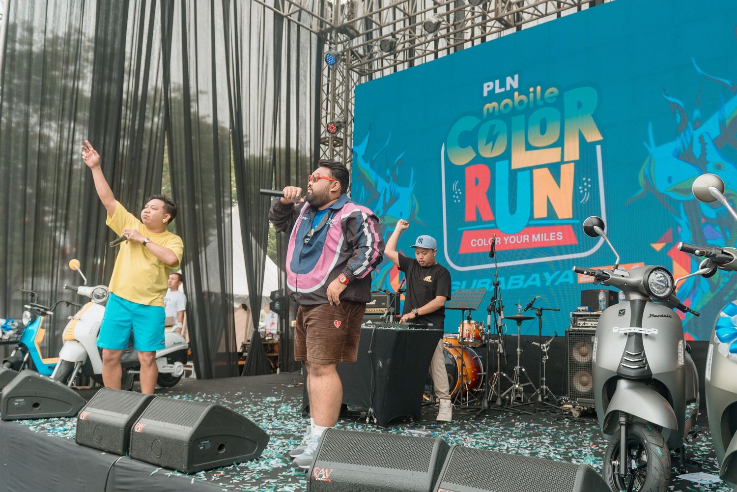 Collage of performers dancing energetically on stage against a bright blue backdrop during a live show.