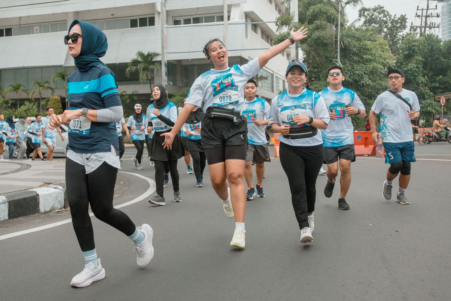 Participants performing synchronized leg kicks during an outdoor group fitness class in a parking lot.
