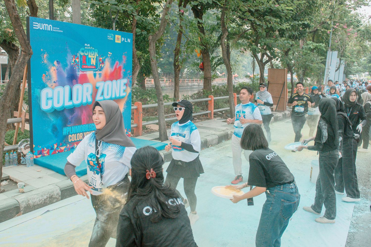 People practicing martial arts moves outdoors in a park setting with trees in the background.