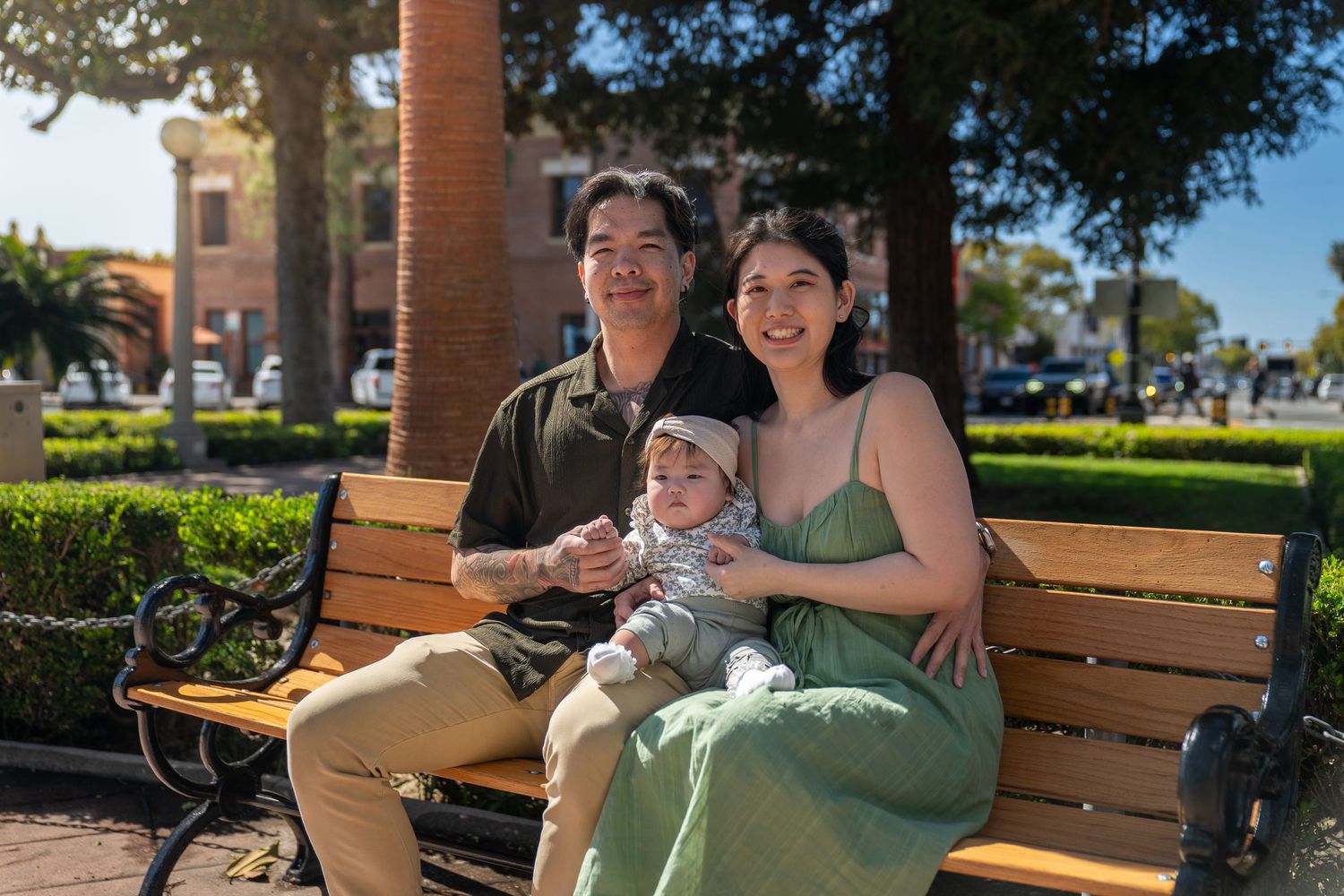 People enjoying a sunny day sitting on wooden benches in an outdoor park setting.
