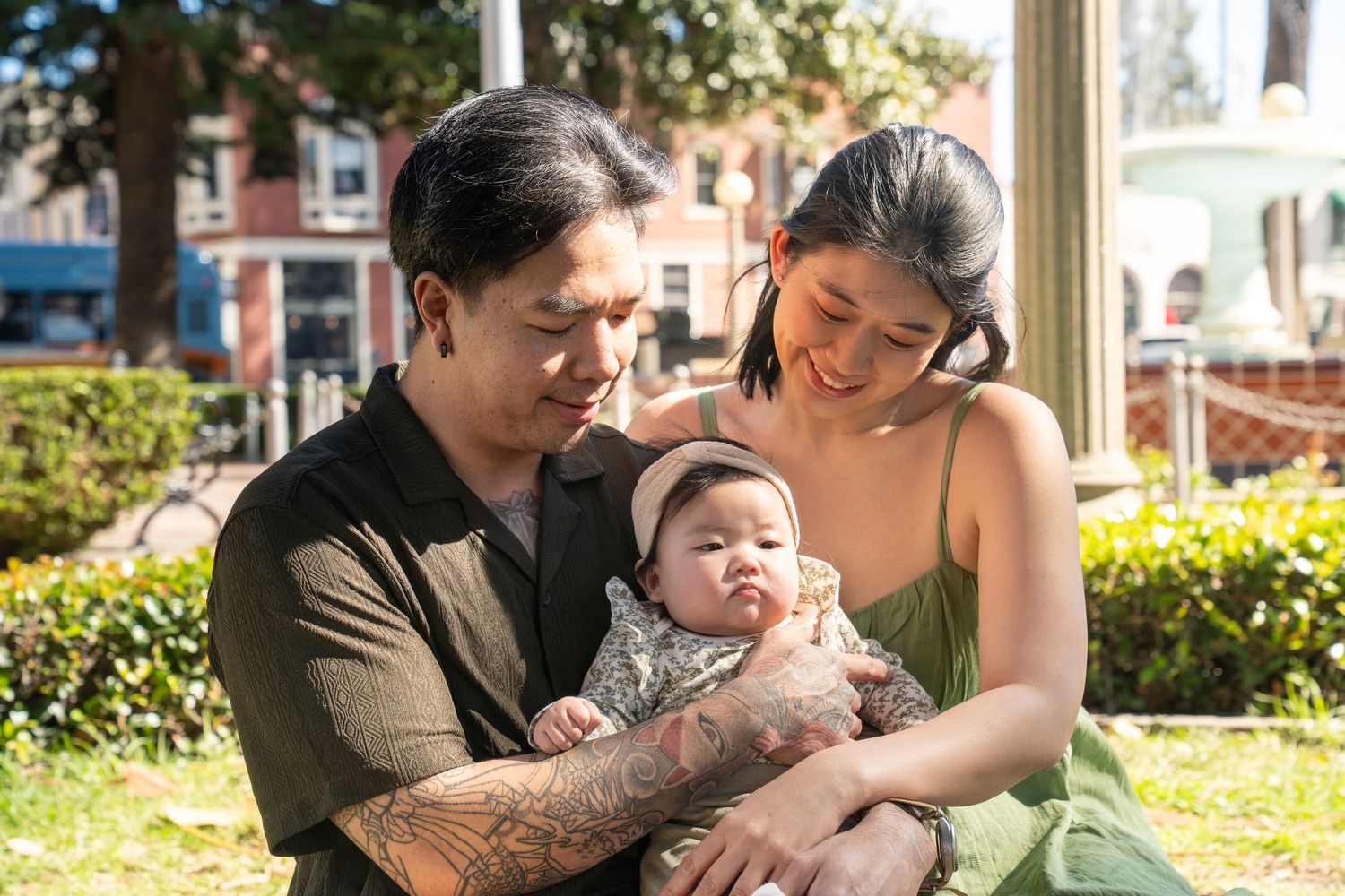 Family sharing tender moments together while relaxing in an outdoor garden setting.