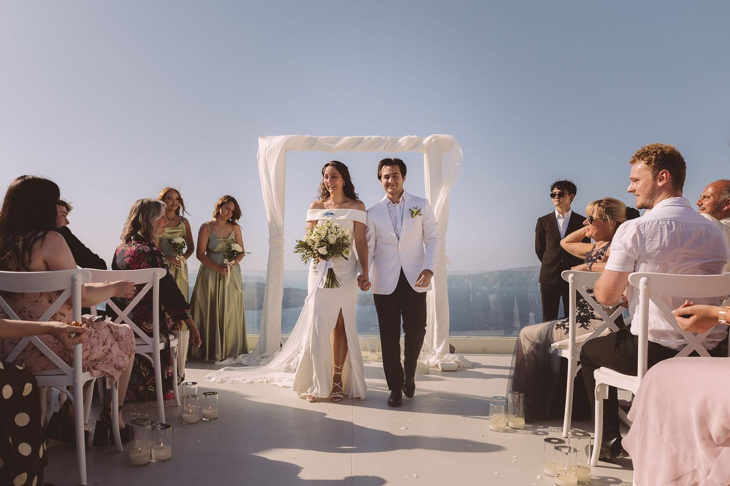 A panoramic wedding ceremony at El Viento showing guests gathered on a scenic seaside terrace at Santorini.