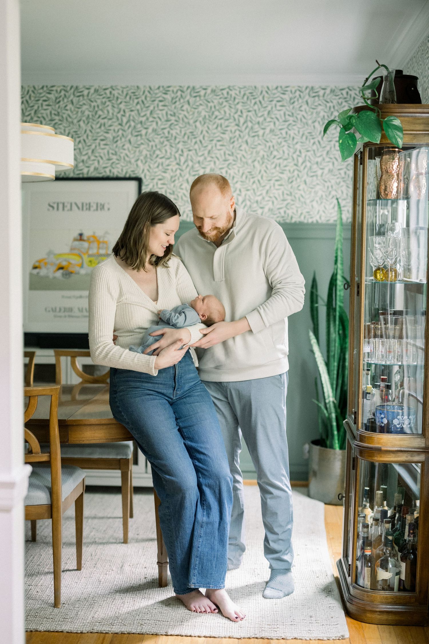 couple holding newborn  in their dining room taken by a Reston Newborn Photographer