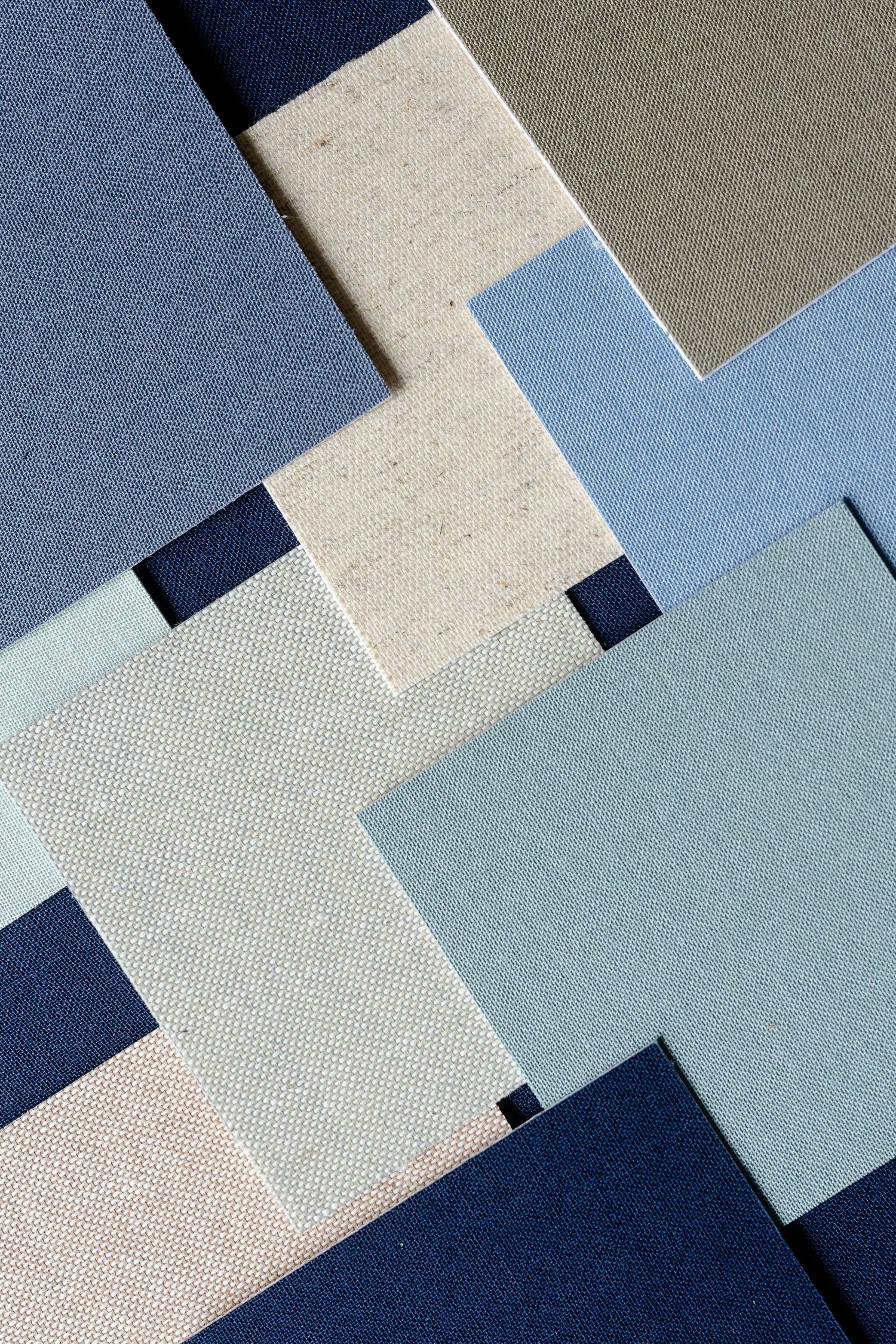 Geometric pattern of overlapping paper squares in various shades of blue and gray creating a modern design layout.