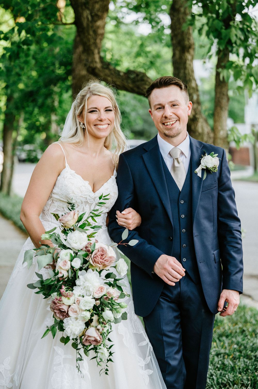 Wedding couple shares joyful moments together in an outdoor garden setting with elegant attire.