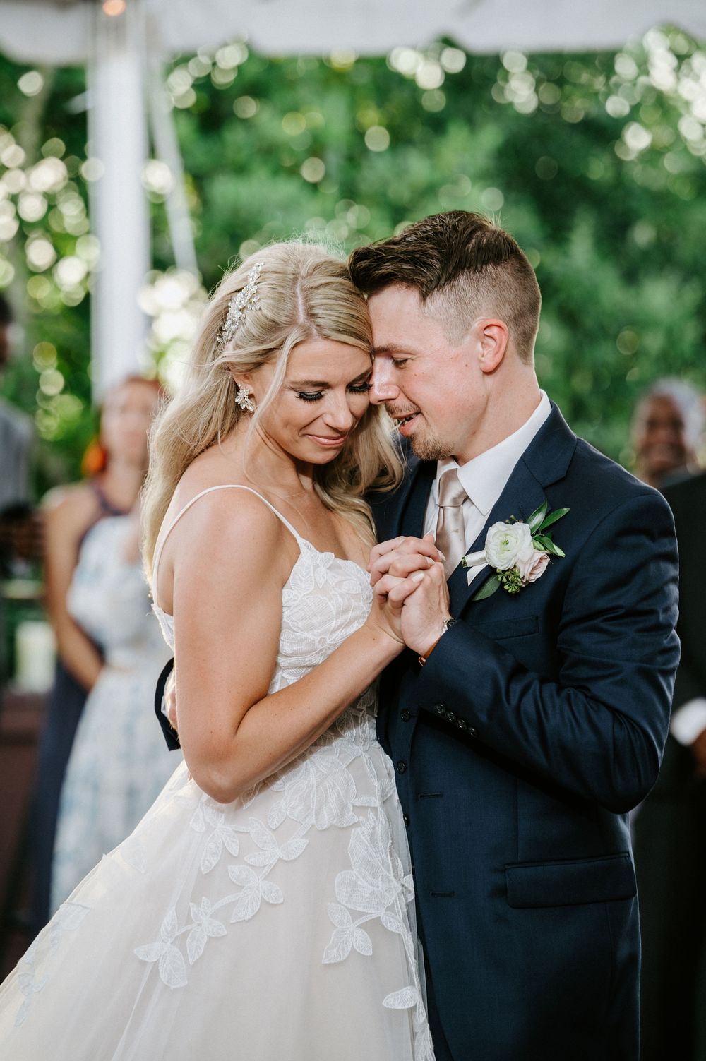 Tender moments between newlyweds during an outdoor wedding ceremony with natural greenery backdrop.