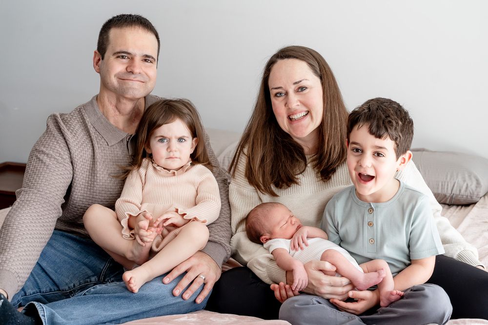 A series of candid family photos showing tender moments between parents and children on a light gray couch.