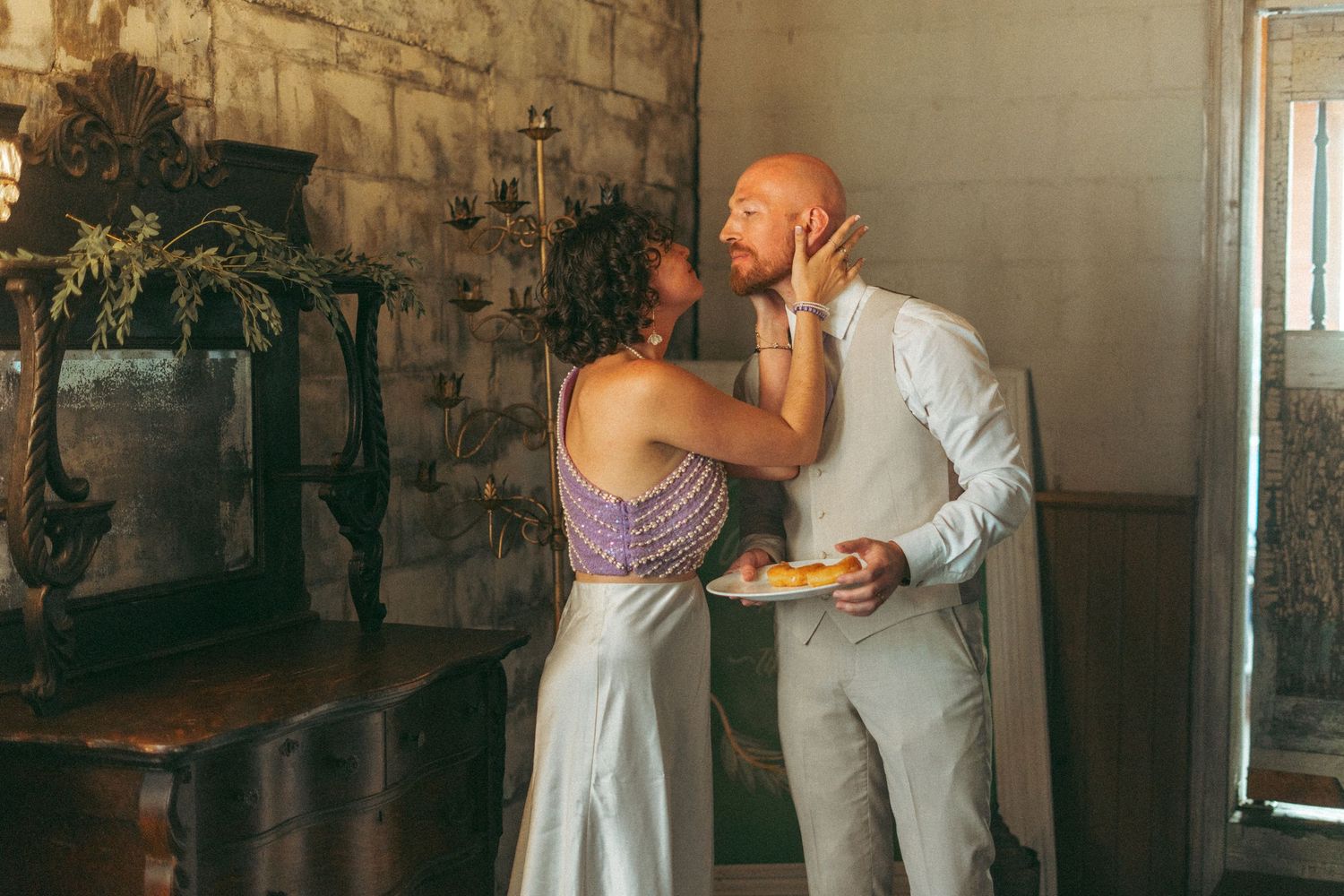 Bride tenderly touching grooms face during their rustic wedding reception.
