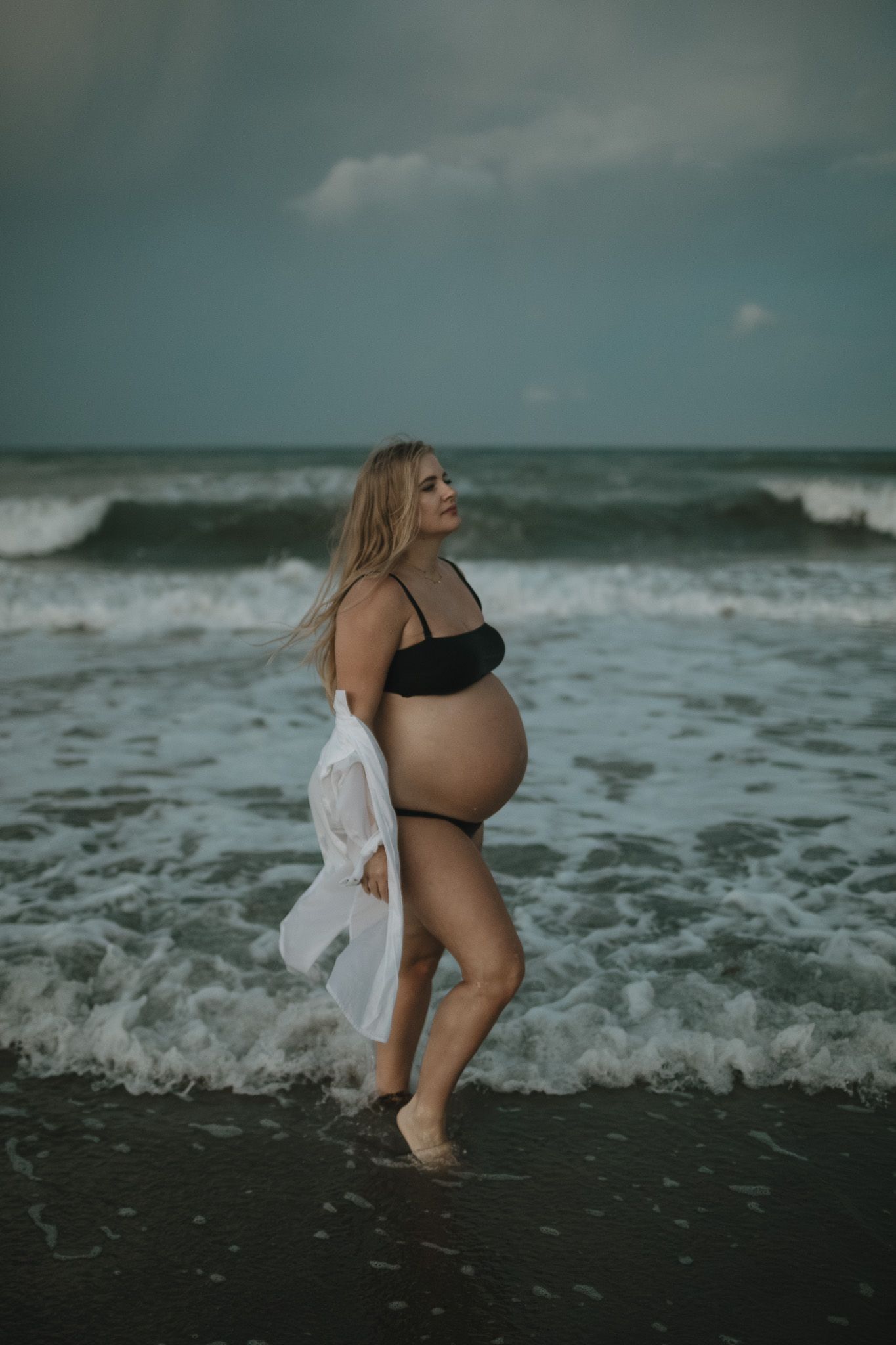 sunset maternity photoshoot on Hutchinson Island with warm ocean waves in the background.