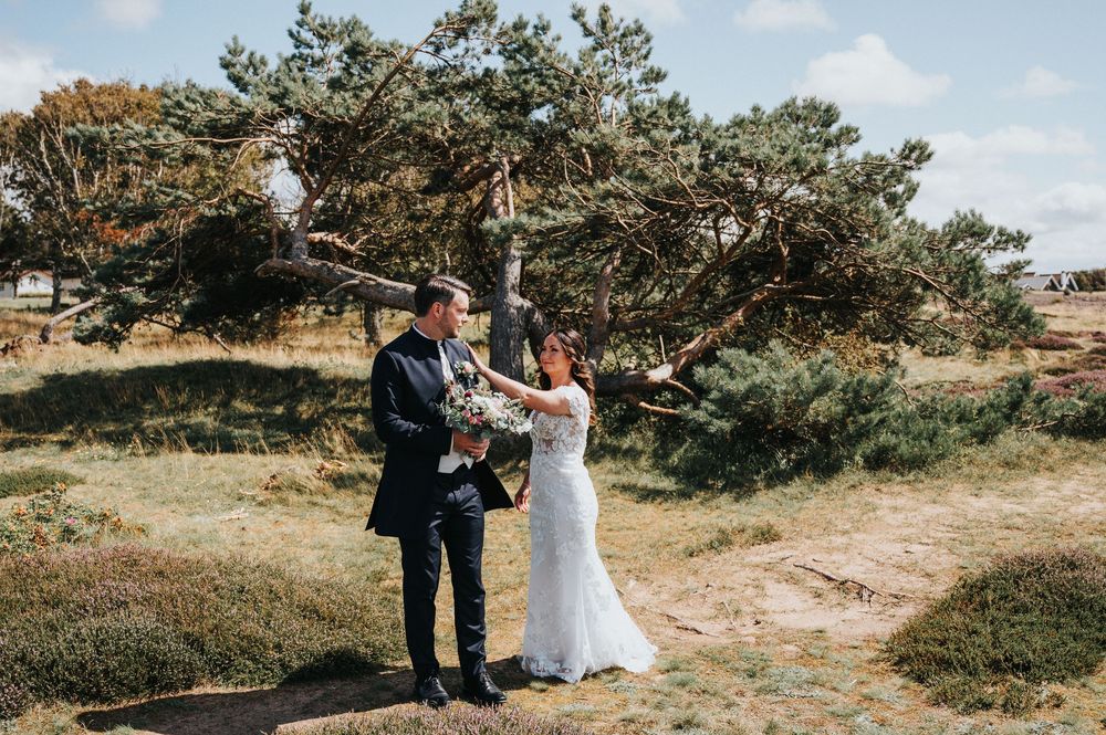 A scenic outdoor wedding ceremony with trees and natural landscape in the background.