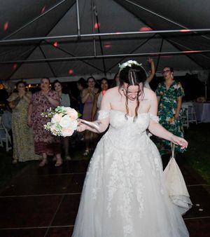Wedding guests dance under red laser lights on a dark dance floor at an outdoor reception celebration.