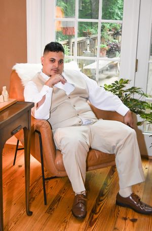 Series of photos showing person in white suit lounging casually in brown leather chair against hardwood floor.
