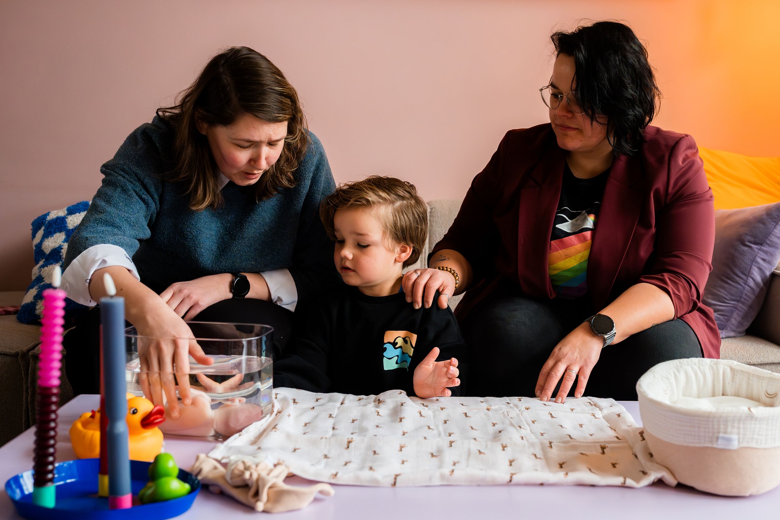 A sequence of photos showing children and adults working together on an art or craft project at a table.