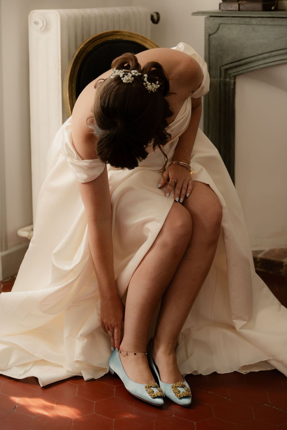 Mariée vêtue de sa belle robe qui mets ses ballerines bleue Manolo Blahnik.