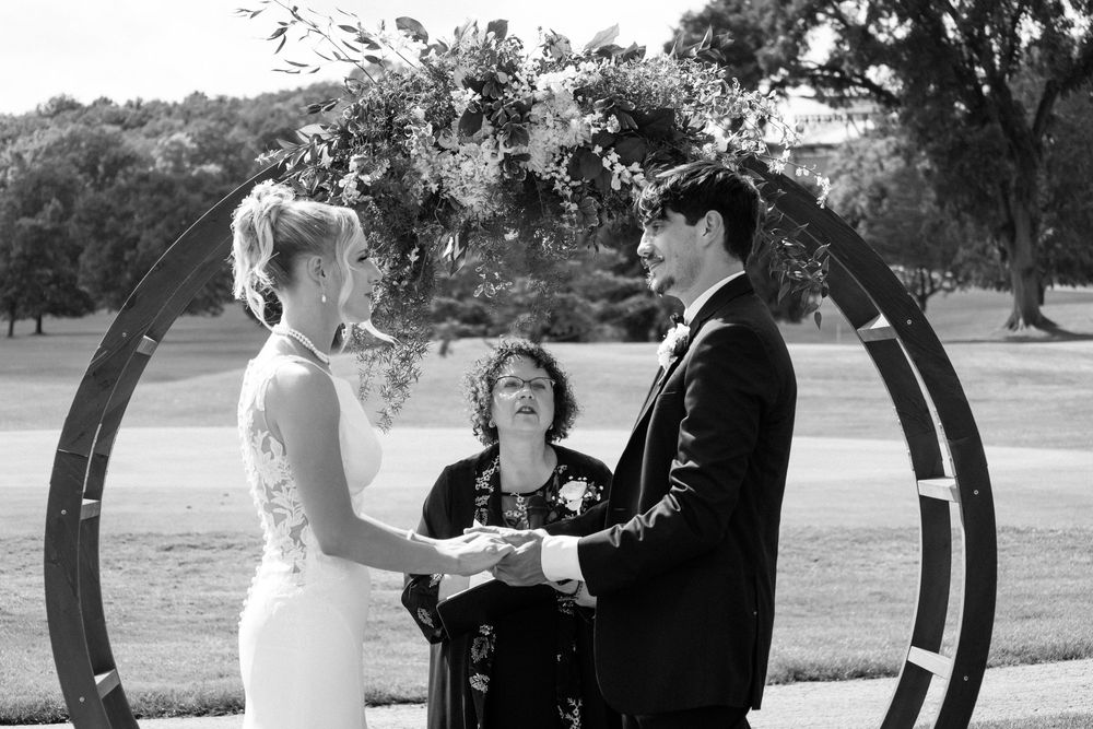 A romantic black and white wedding photo sequence showing intimate moments between a couple under outdoor arches.