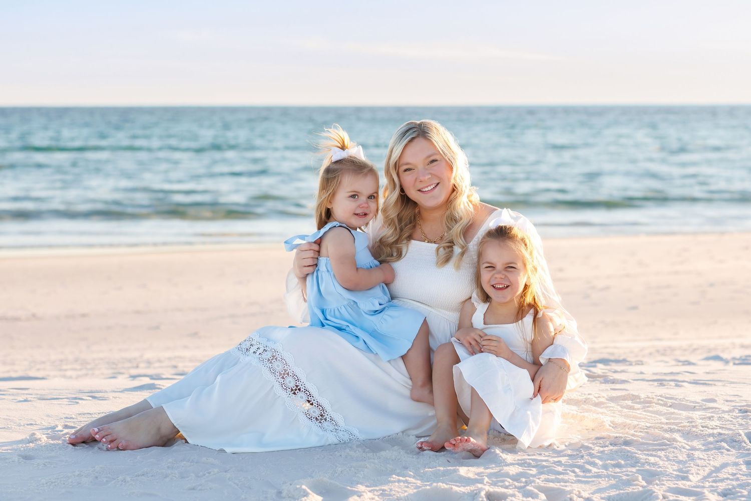 Mom holding her two children in the sand on the beach in Destin, Florida