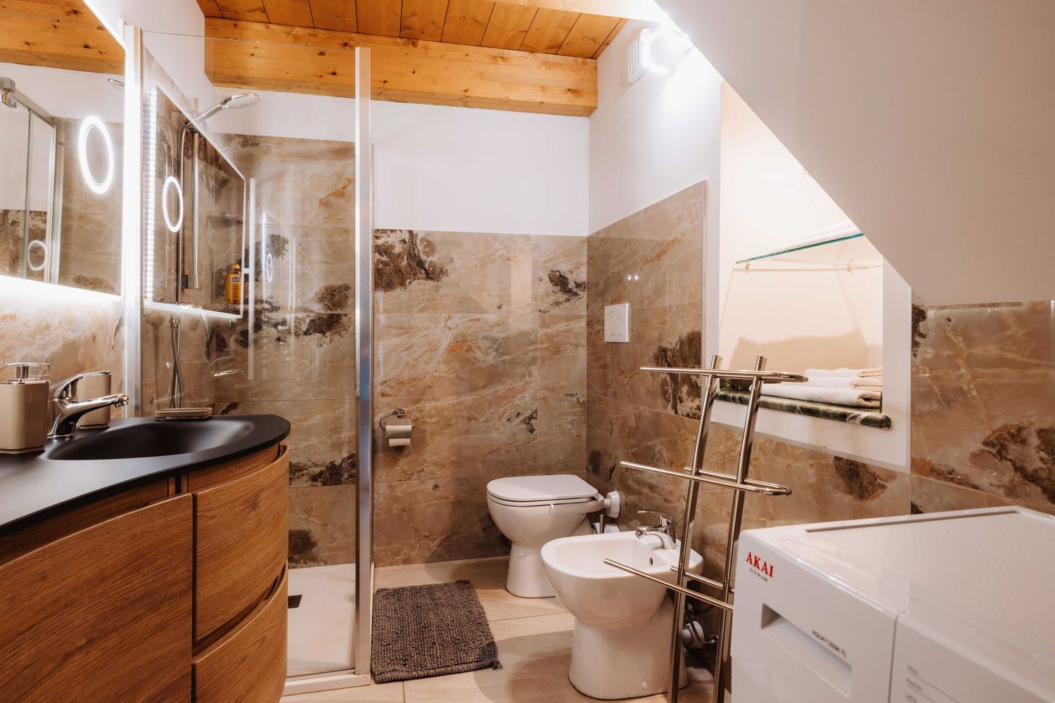 Contemporary bathroom with wooden ceiling, marble-look tiles, glass shower enclosure and floating vanity cabinet.