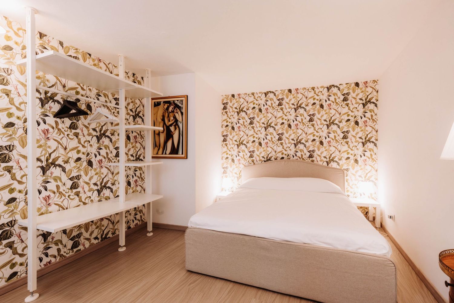 Modern white bedroom with floral wallpaper design wrapping around the walls and ceiling creates an immersive garden effect.