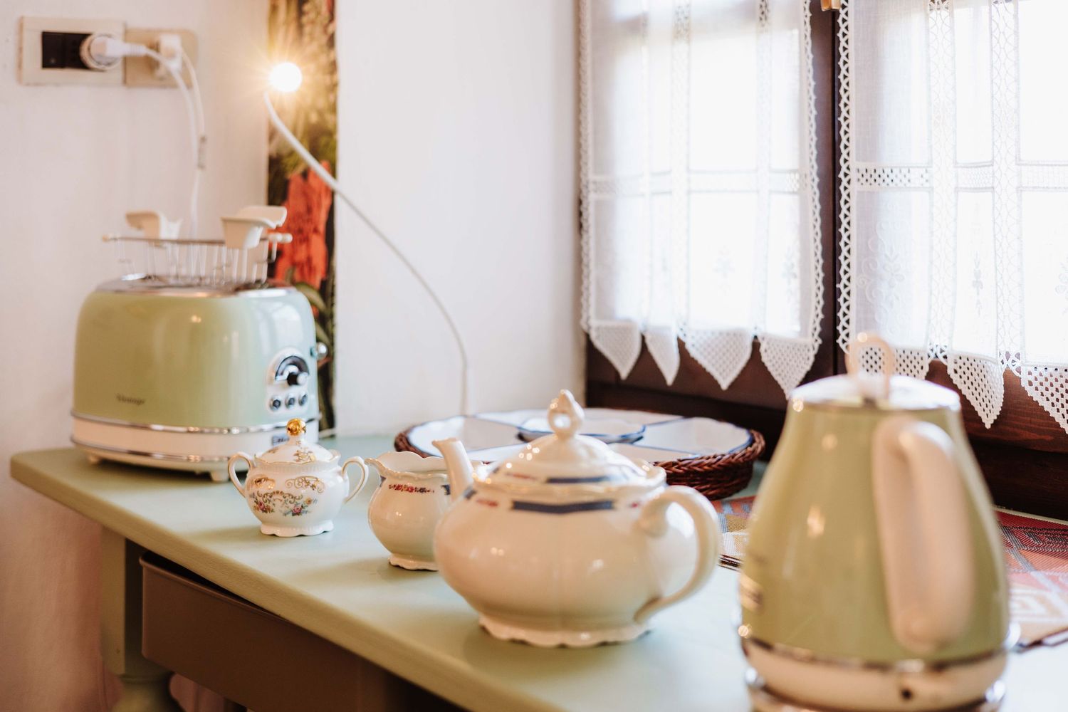 White ceramic teapots and cups displayed on wooden shelves in a bright, minimalist interior setting.