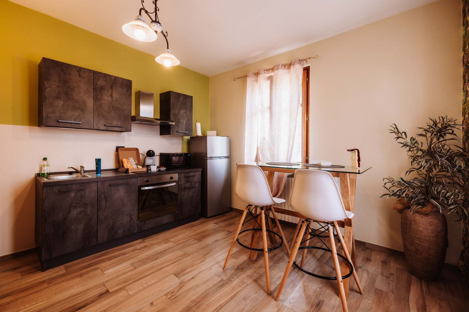 Modern apartment interior with hardwood flooring, white walls, and minimalist furniture in a bright, open layout.