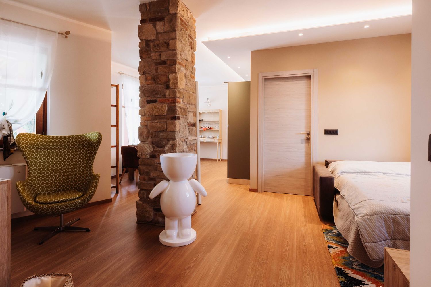 Modern hotel room interior with light wood flooring, white walls, and minimalist furnishings in a panoramic view.