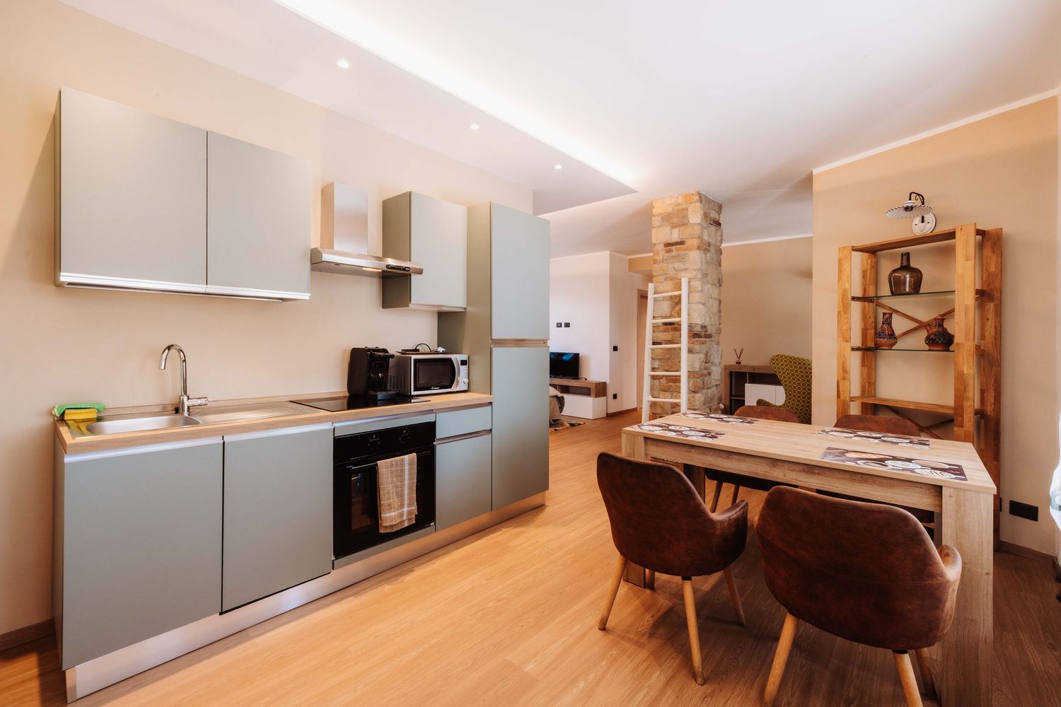 Modern minimalist apartment interior with sleek gray cabinets, wooden accents and open concept design.