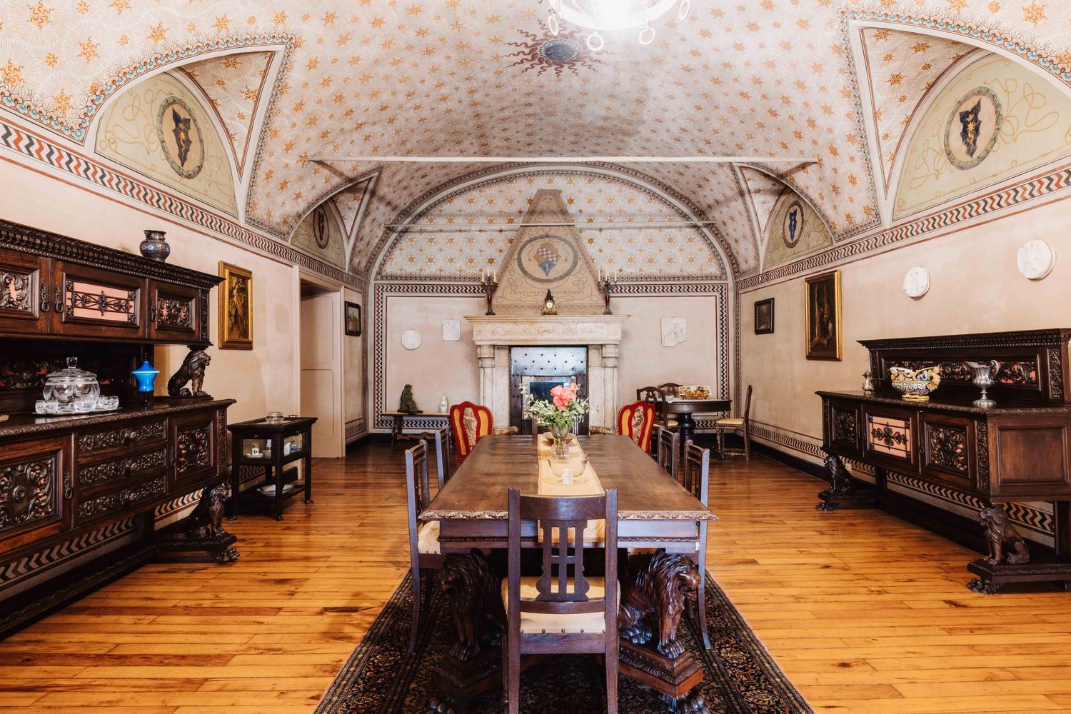 A panoramic view of an ornate historic church interior with wooden pews, vaulted ceilings and polished hardwood floors.