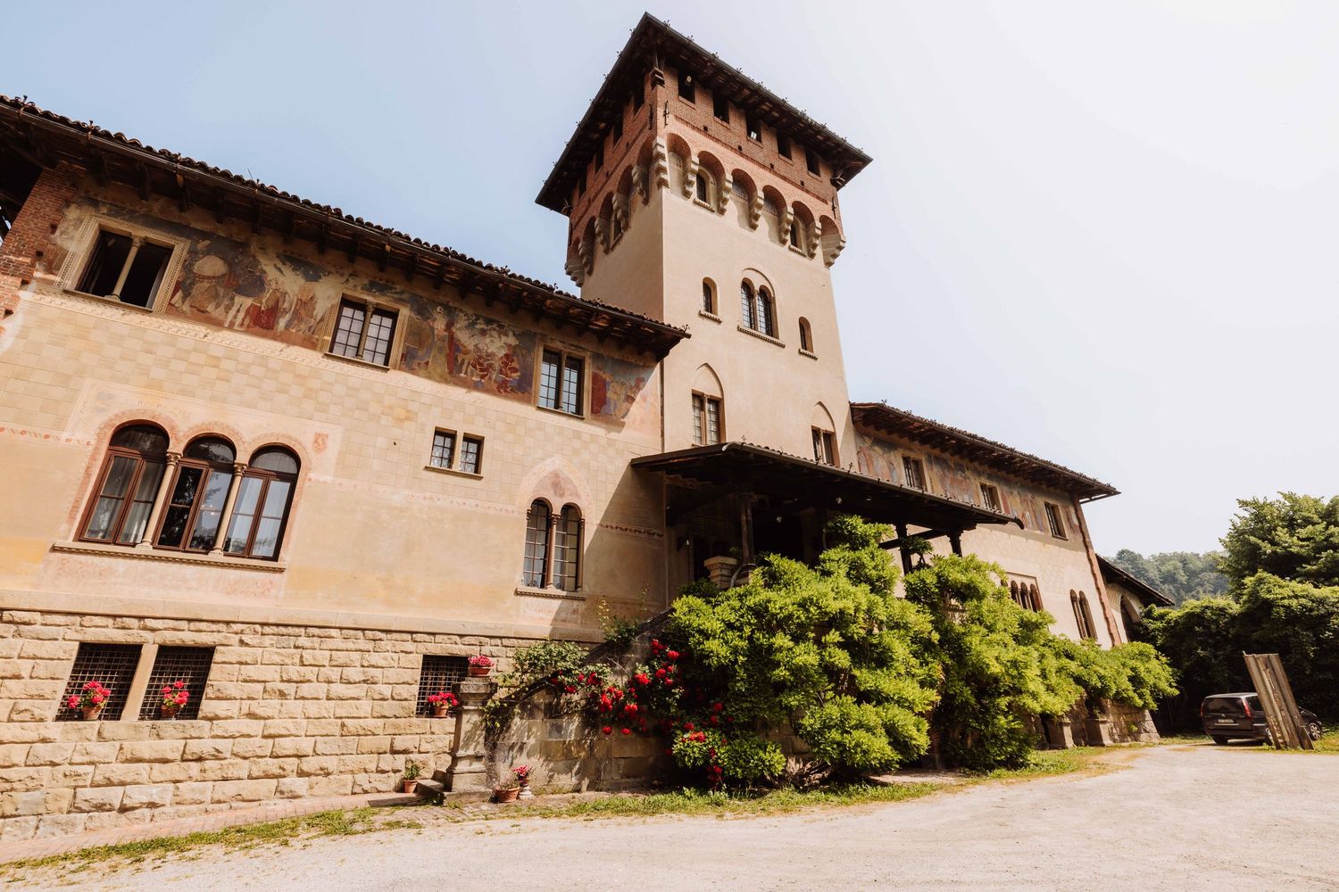 Historic stone castle building with arched windows and tower photographed from multiple angles in natural daylight.
