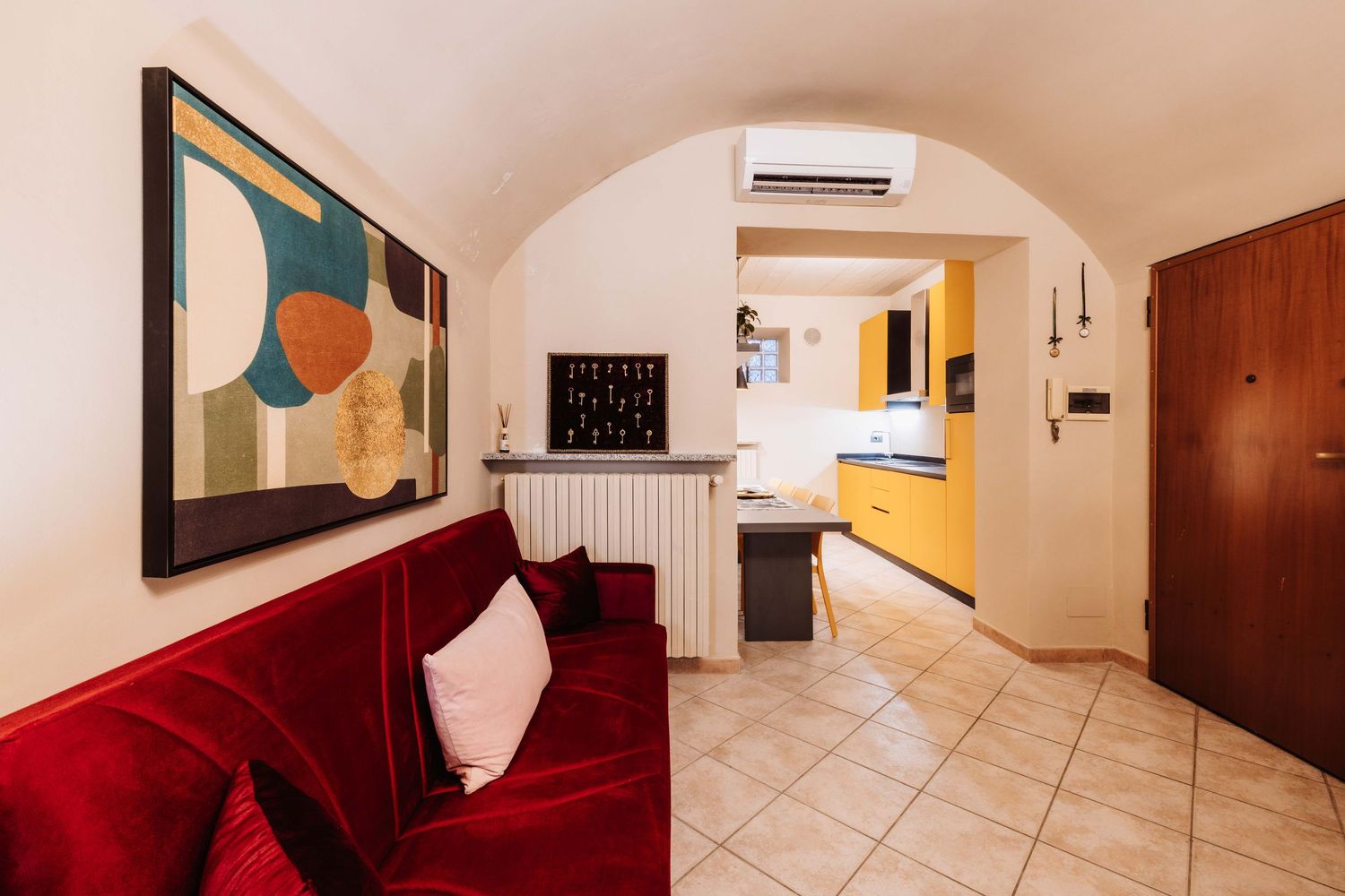 Modern hotel room interior with white walls, tiled floors, and split air conditioning unit mounted on the wall.