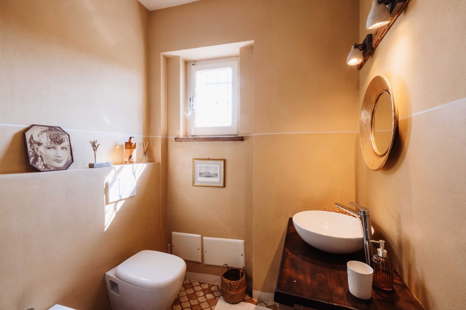 Panoramic view of a modern bathroom interior with beige walls, white fixtures and natural lighting from small windows.
