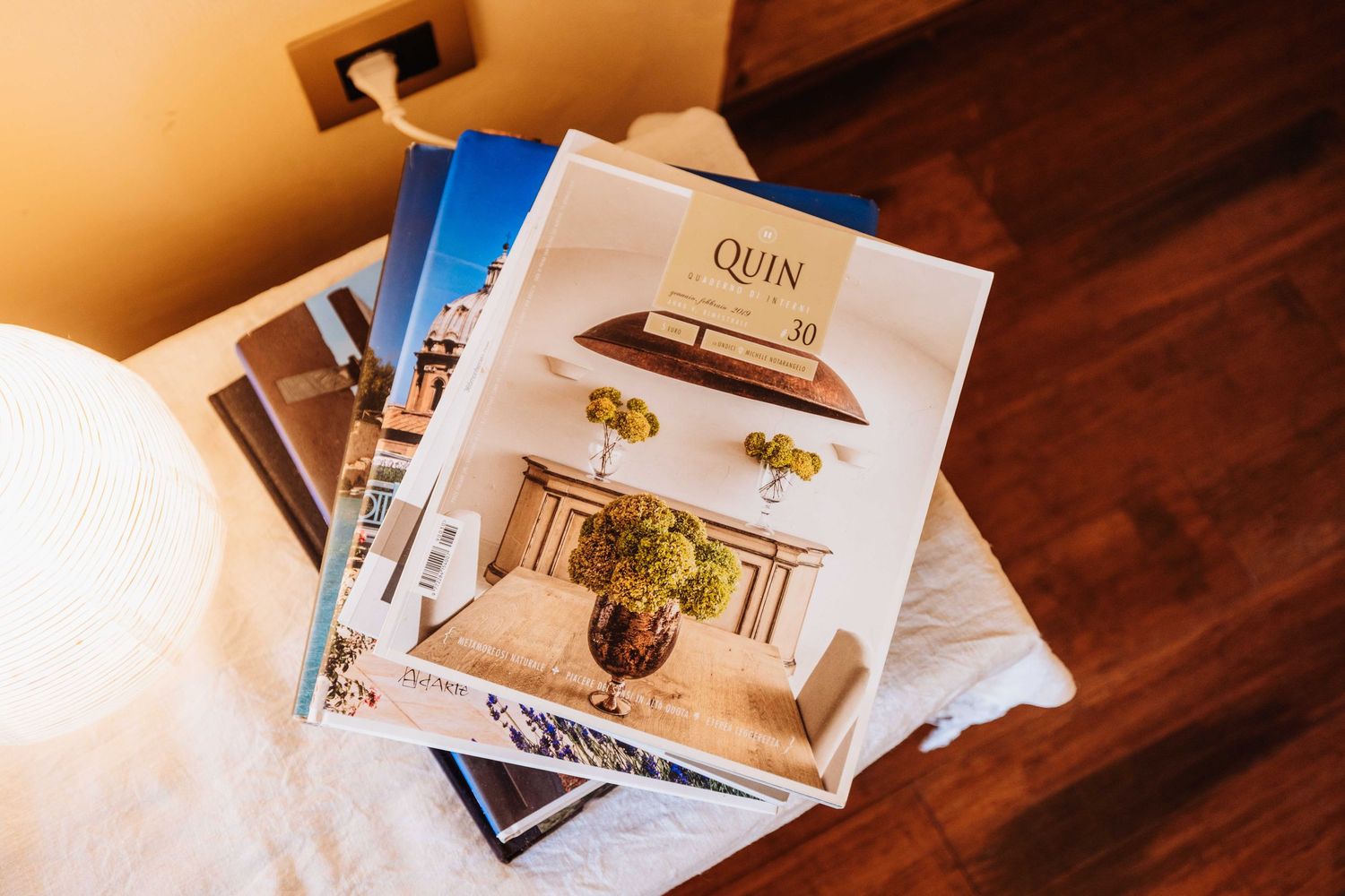 Wedding magazines and brochures spread out on a white surface with warm lighting.
