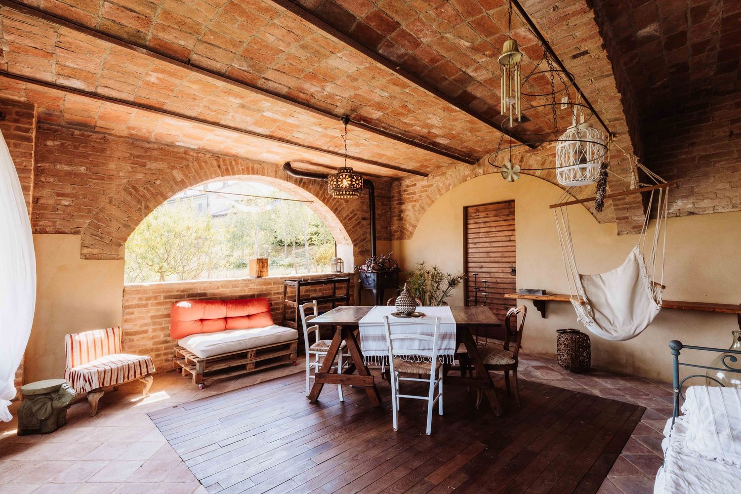 Rustic wooden beams and exposed brick walls create a panoramic view of a historic interior space with natural lighting.