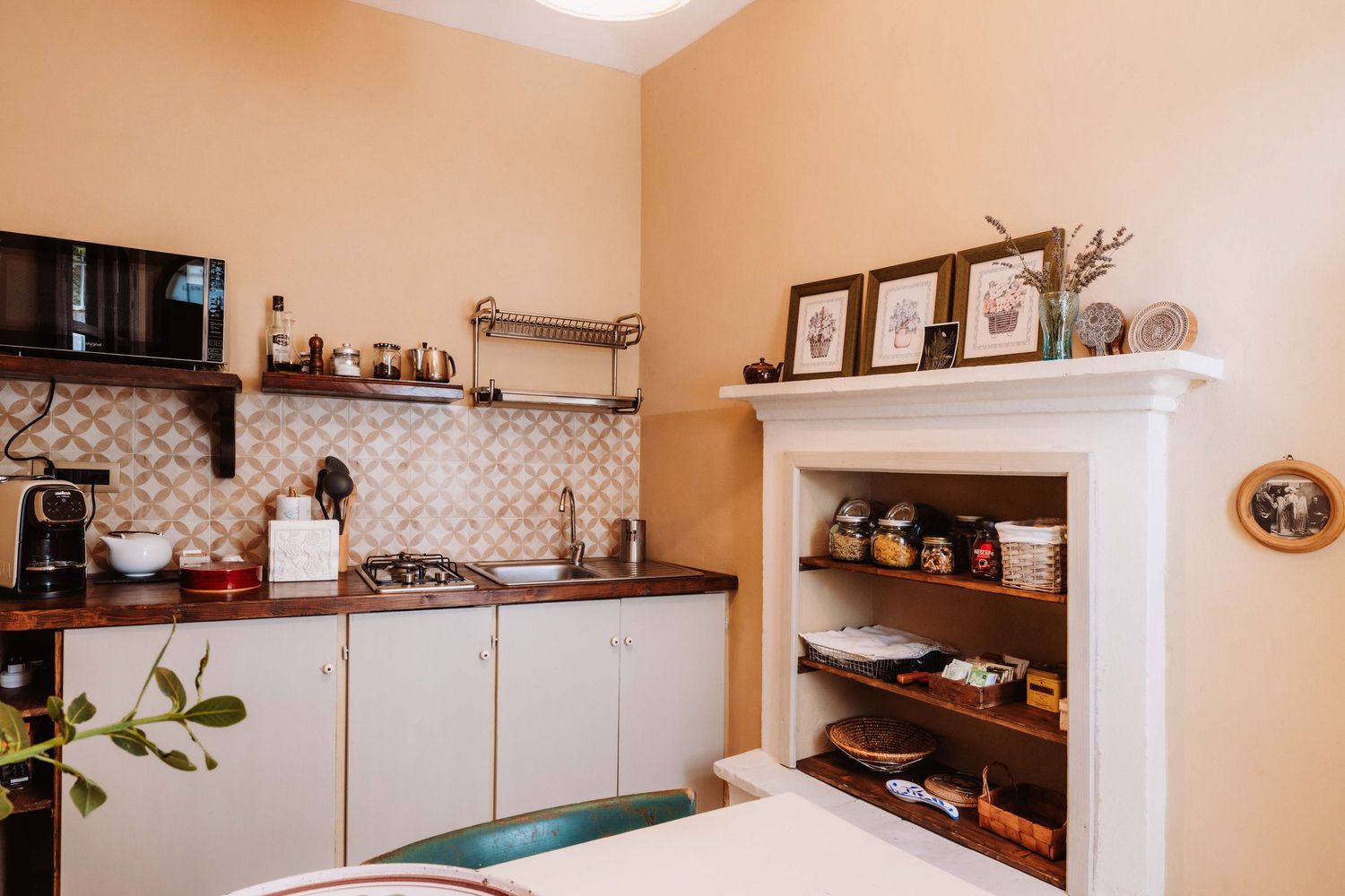 Modern kitchen interior with white cabinets, tile backsplash, and open shelving displaying cookware and decor.