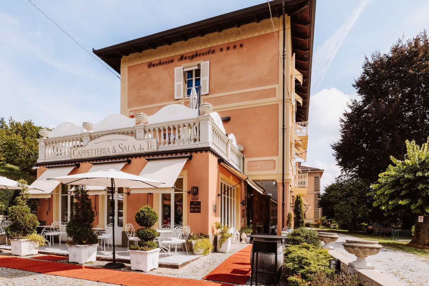 Exterior collage of a luxury hotel property showcasing multiple views of the building and grounds in warm sunlight.